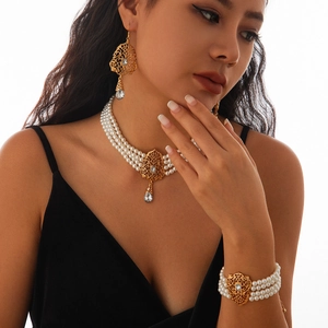 Detalle de conjunto de collar de perlas de tres capas con metal dorado y cristales finos