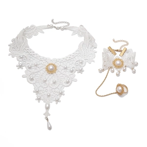Detailansicht von weißem Spitzenhalsband mit Perlen und passendem Fingerring-Armband