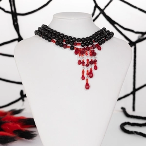 Gothic choker featuring black beads and red teardrop crystal tassels on a mannequin neck