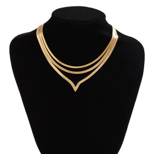 Close-up of triple-layered golden herringbone chains with a V-shaped pendant on black bust