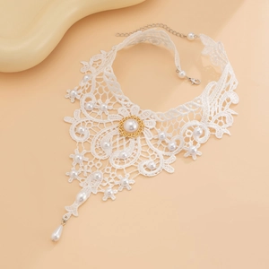 Detailansicht des weißen Spitzen-Chokers mit Perlenverzierung und goldenem Metallelement