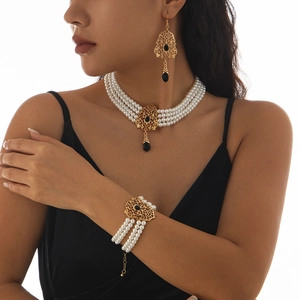 Detalle del collar de perlas vintage multicapa y gemas negras sobre la modelo