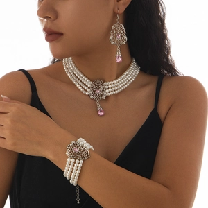 Detalle de conjunto de collar de perlas de cuatro filas con gemas rosas en forma de pera