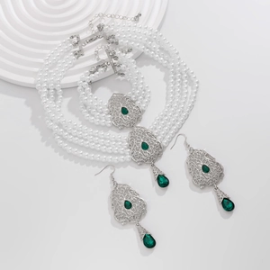 Detalle de set de joyas vintage con perlas y piedras preciosas verde esmeralda