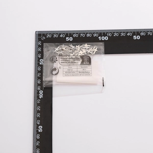 Macro shot of silver metal cross pendants measured against a professional scale ruler