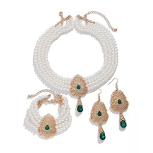 Detalle de set de joyas de perlas vintage con gemas verdes y filigrana dorada