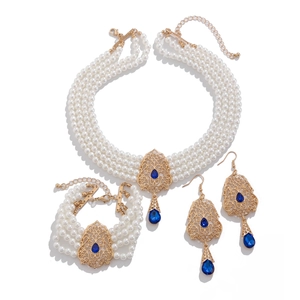 Detalle de conjunto de joyas de perlas con gemas azules y filigrana bañada en oro