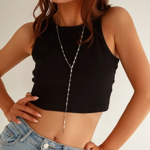 Detail of silver Y-shaped long necklace with small cross charms on a model