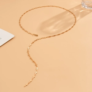 Detail of golden cross chain link necklace with lobster clasp closure on aesthetic background
