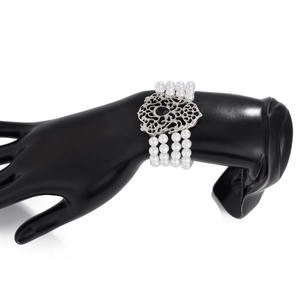 Detalle de pulsera de perlas de cuatro capas con filigrana barroca y piedra negra