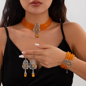 Detalle de joyas con cuentas naranjas, filigrana plateada y gotas de cristal
