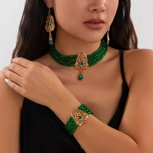 Vista detallada del juego de joyas bohemio dorado con gemas verdes en forma de lágrima