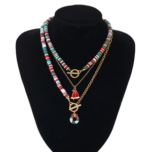Detail van de 3-laagse kerstketting met feestelijke hangers en heishi kralen