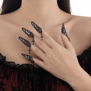 Makroaufnahme von schwarzen Gothic-Fingerspitzenringen mit Kreuzanhängern und Mustern