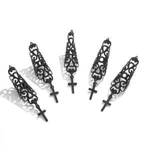 Nahaufnahme schwarzer Gothic-Nagelringe mit hohlen Schnitzereien und Kreuzanhänger
