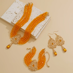 Detalle de set de joyas bohemias de cuatro capas con cuentas naranjas y dorado