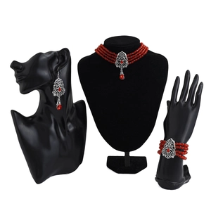 Detalle de conjunto de joyas bohemias con cuentas rojas y filigrana de plata retro