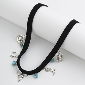 Détail du collier western avec crâne de taureau, chapeau de cowboy et pendentifs