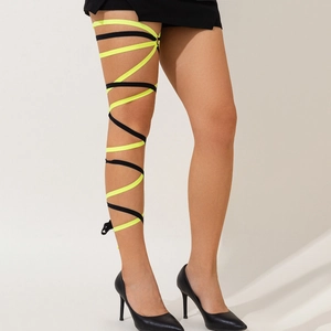 Detail of neon yellow and black elastic leg wraps shown on leg with high heels