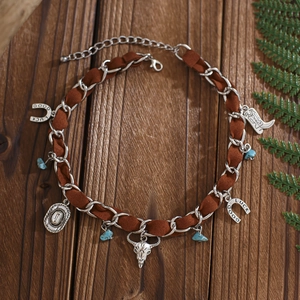 Détail du collier style Western avec crâne de taureau et fer à cheval sur cordon daim