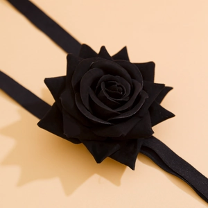 Close-up of a black fabric rose leg chain with intricate layered petal design and texture