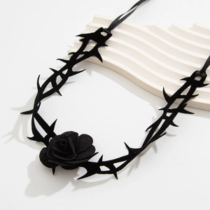 Nahaufnahme von Gothic-Halsband mit schwarzer Rose und Samt-Dornenrebe auf Weiß