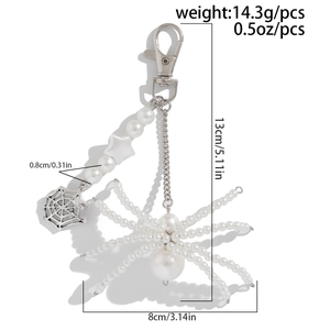 Detailed view of beaded spider keychain with white pearls and silver lobster clasp