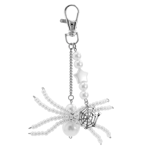 Detail of silver spider keychain with white pearls, star charms and spider web pendant
