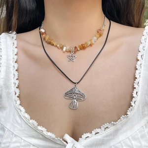 Detail van bohemien gelaagde ketting met turquoise kralen en een zilveren paddenstoel