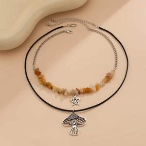 Detail van de dubbellaagse ketting met paddenstoel hanger en oranje stenen kralen