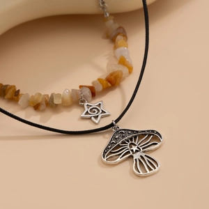 Detail van de boheemse gelaagde ketting met paddenstoelhanger en gele natuurstenen kralen