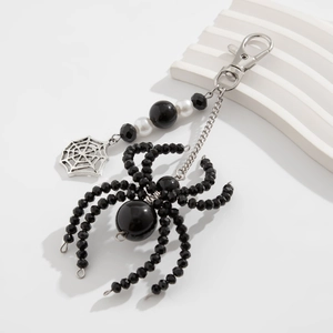 Detailed view of handmade spider keychain with black crystal beads and silver spiderweb charm
