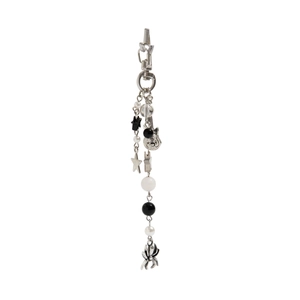Detailed close-up of gothic keychain with silver spider, guitar, and pearl charms