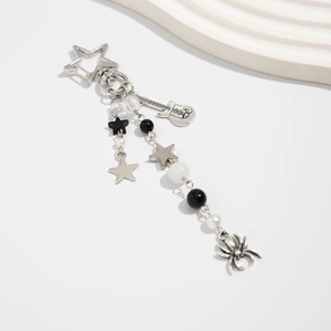 Close-up of gothic spider keychain with silver guitar charm and black beaded star detail
