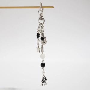 Silver guitar keychain with black star charm and monochrome bead detail on a metal bar