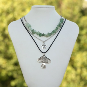 Detail van een bohemien gelaagde ketting met paddenstoelhanger en groene kralen