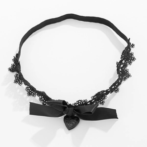 Detail eines schwarzen Spitzenstrumpfbands mit Satinschleife und Herzanhänger