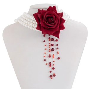 Detail of multilayer pearl necklace with velvet rose and red bead tassels on model