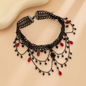 Detail view of retro gothic choker with black lace, metal tassels and red crystal drops