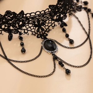 Detailed close-up of gothic black lace choker with central gem and tassel chains