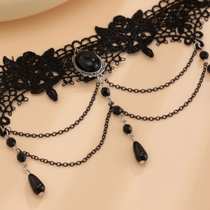 Detail of gothic lace choker featuring a black gemstone and layered metal tassel drops
