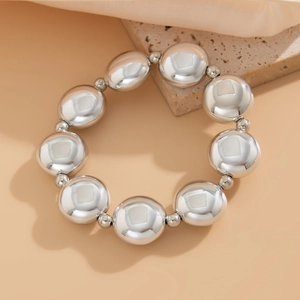 Détail de grandes perles métalliques argentées avec finition brillante sur un bracelet
