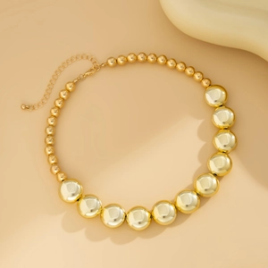 Détail du collier à billes dorées dégradées avec fermoir mousqueton et chaîne d'extension