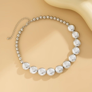 Détail du collier de perles argentées montrant des perles dégradées et un éclat poli