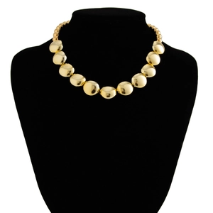 Gros plan d'un collier à grosses perles dorées avec finition miroir sur support noir