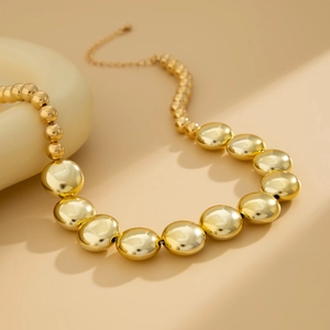 Collier doré style punk avec perles géométriques dégradées sur un support élégant