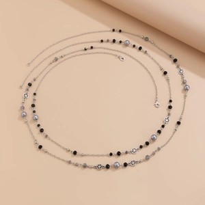 Detailed view of long beaded pearl necklace with silver chain and star charms