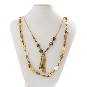 Detail of bohemian layered necklace with turquoise discs, wood beads and gold tassels
