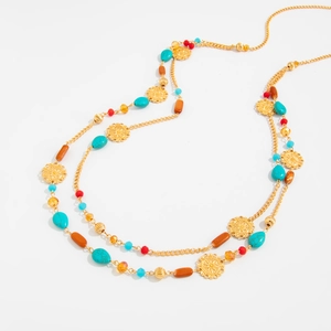 Detail of bohemian layered necklace with turquoise beads and gold floral charms