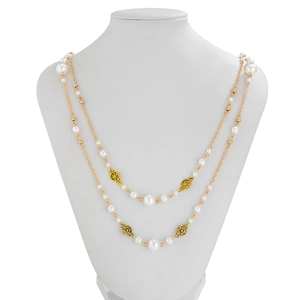 Detail of double-layer gold chain necklace with white pearls and hollow pattern charms